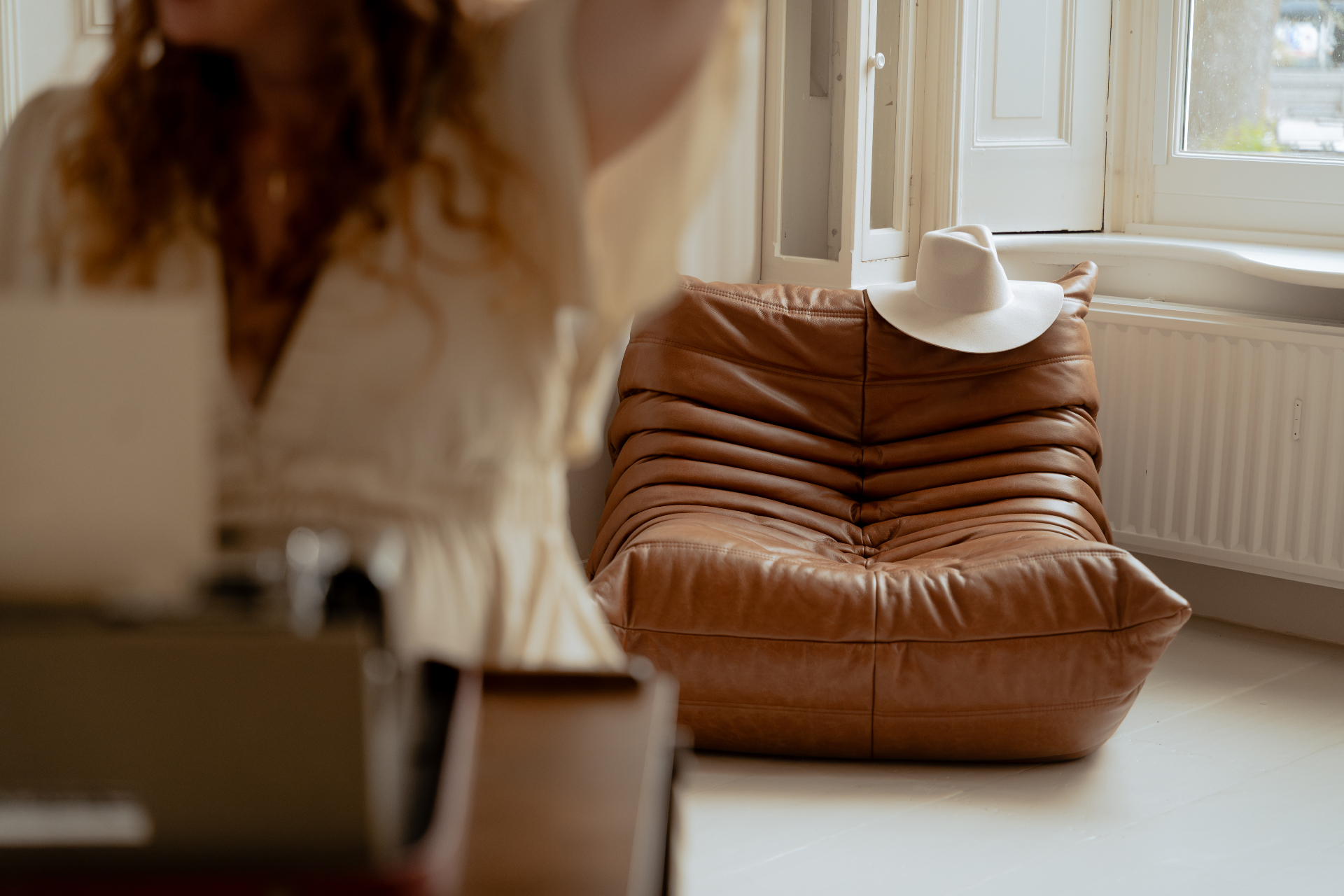 Aan het werk — typemachine, hoed en warme togo-fauteuil